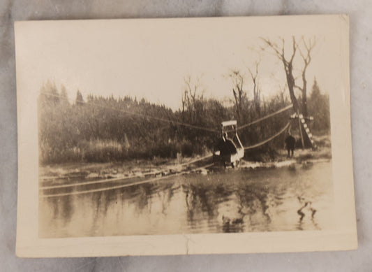 Lot 100 - Single Antique Snapshot Photograph Of A Man Crossing A River On A Makeshift Rope And Pulley Trolley, Taken In New Hampshire