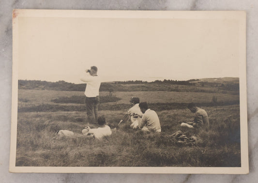 Lot 102 - Single Antique Snapshot Photograph Of A Group Of Young Men In A Field, One Taking A Photo, Another Looking Through Binoculars