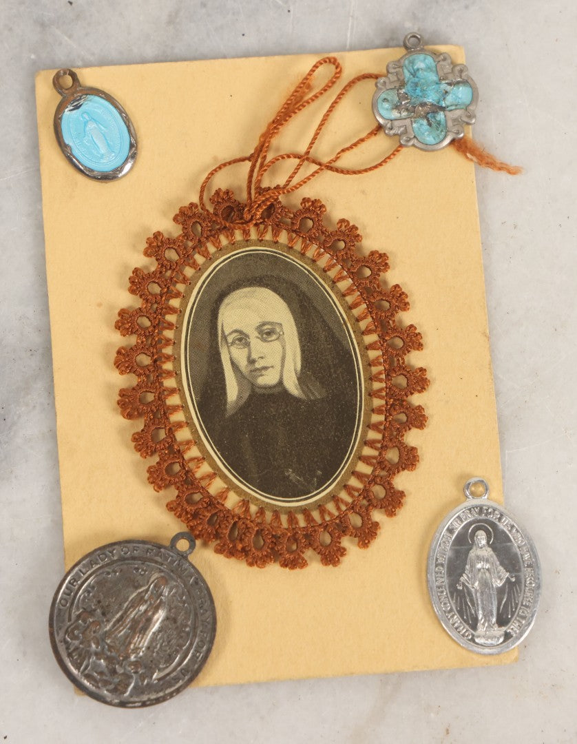 Lot 032 - Grouping Of Five Religious Devotional Smalls Including Prayer Card Of Unknown Nun With Lace Border, Four Metal Religious Charms