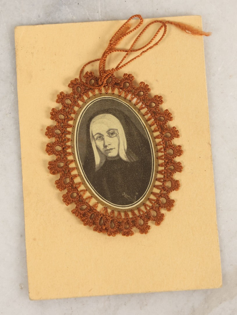 Lot 032 - Grouping Of Five Religious Devotional Smalls Including Prayer Card Of Unknown Nun With Lace Border, Four Metal Religious Charms