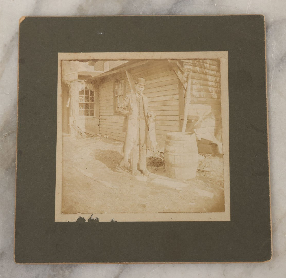 Lot 049 - Antique Boarded Photograph Of A Man In A Bowler Hat Posing With The Days Catch, Two Large Fish