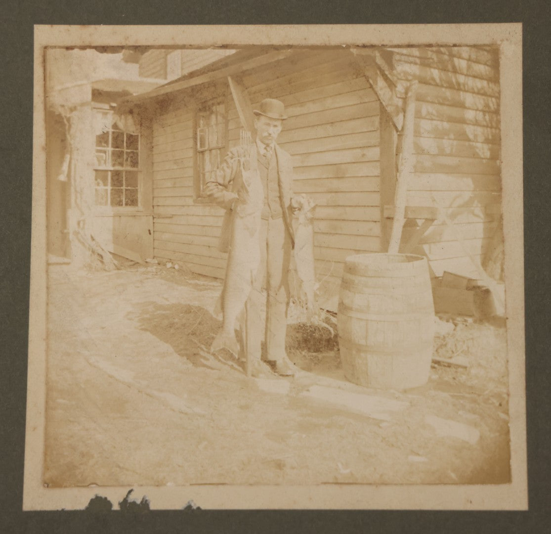 Lot 049 - Antique Boarded Photograph Of A Man In A Bowler Hat Posing With The Days Catch, Two Large Fish