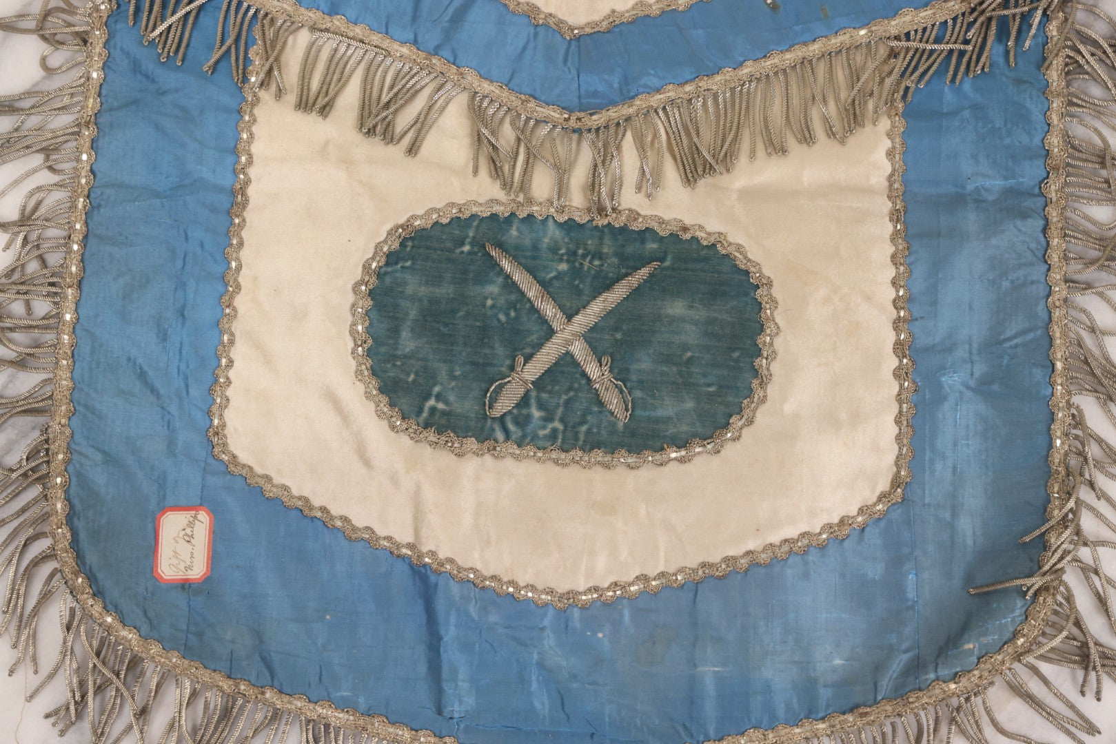 Lot 010 - Antique Odd Fellows I.O.O.F. Fraternal Apron With Embroidered Crossed Swords And Hand Painted All-Seeing-Eye Motifs, Silver Toned Fringe, Blue Coloring