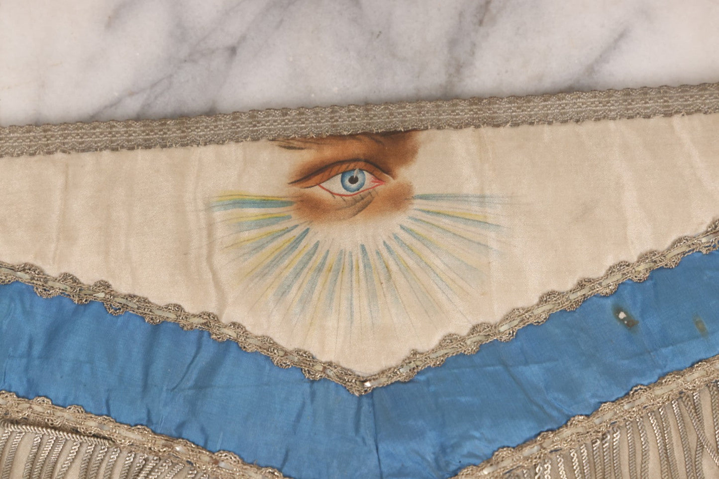 Lot 010 - Antique Odd Fellows I.O.O.F. Fraternal Apron With Embroidered Crossed Swords And Hand Painted All-Seeing-Eye Motifs, Silver Toned Fringe, Blue Coloring