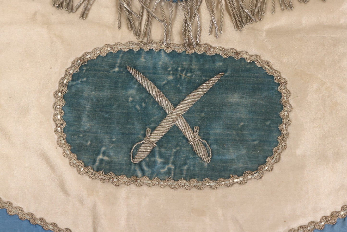 Lot 010 - Antique Odd Fellows I.O.O.F. Fraternal Apron With Embroidered Crossed Swords And Hand Painted All-Seeing-Eye Motifs, Silver Toned Fringe, Blue Coloring
