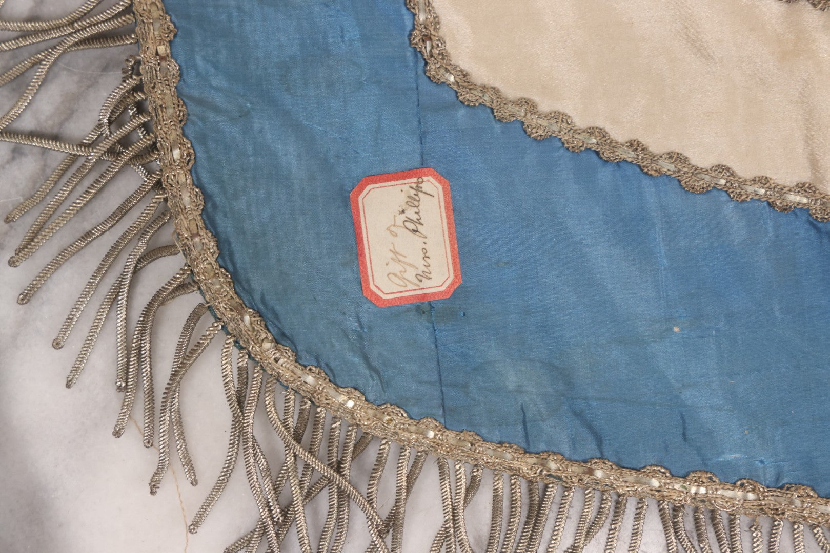 Lot 010 - Antique Odd Fellows I.O.O.F. Fraternal Apron With Embroidered Crossed Swords And Hand Painted All-Seeing-Eye Motifs, Silver Toned Fringe, Blue Coloring