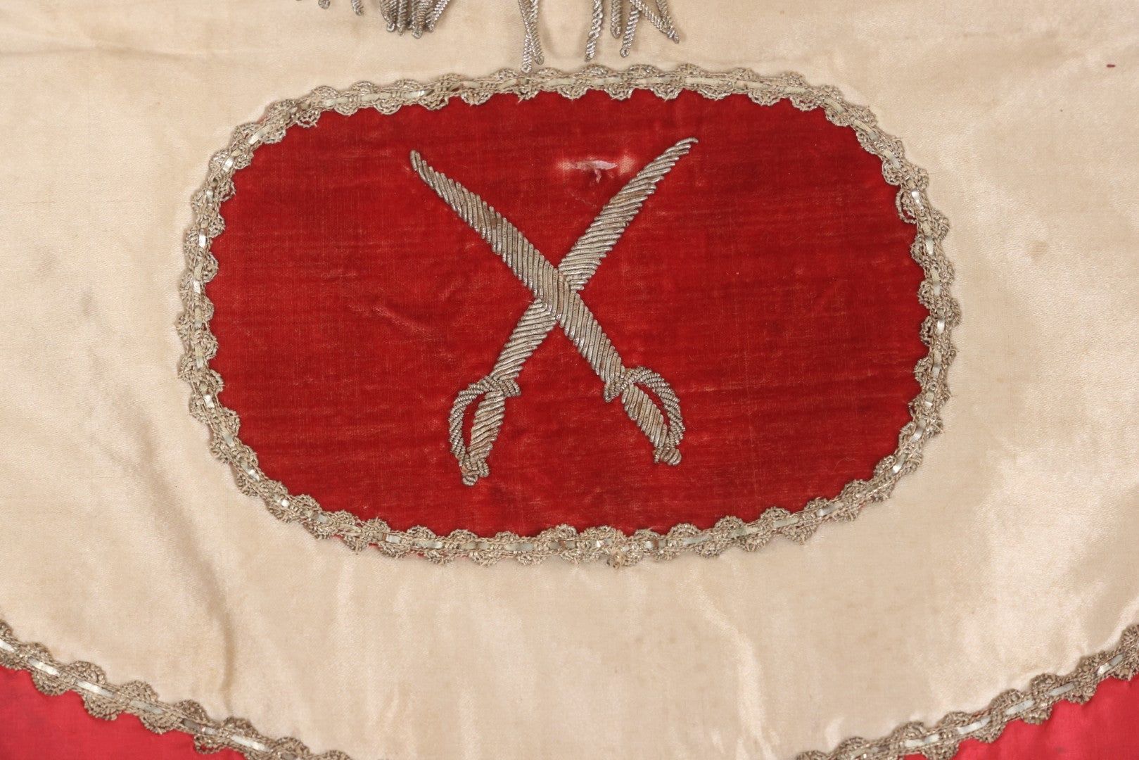 Lot 011 - Antique Odd Fellows I.O.O.F. Fraternal Apron With Embroidered Crossed Swords And Hand Painted All-Seeing-Eye Motifs, Silver Toned Fringe, Red Coloring