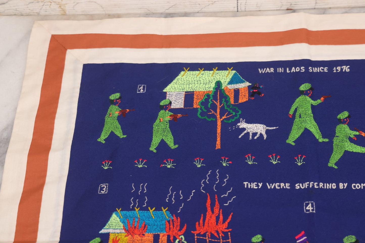 Lot 017 - Pair Of Vintage Folk Art Embroidered Hmong Story Cloths (Paj Ntaub) Illustrating "The War In Laos Since 1976" Across 13 Scenes, Artist Signed Mee Xiong, With Gallery Label From Cama Crafts, Made In Thailand, Circa 1990s