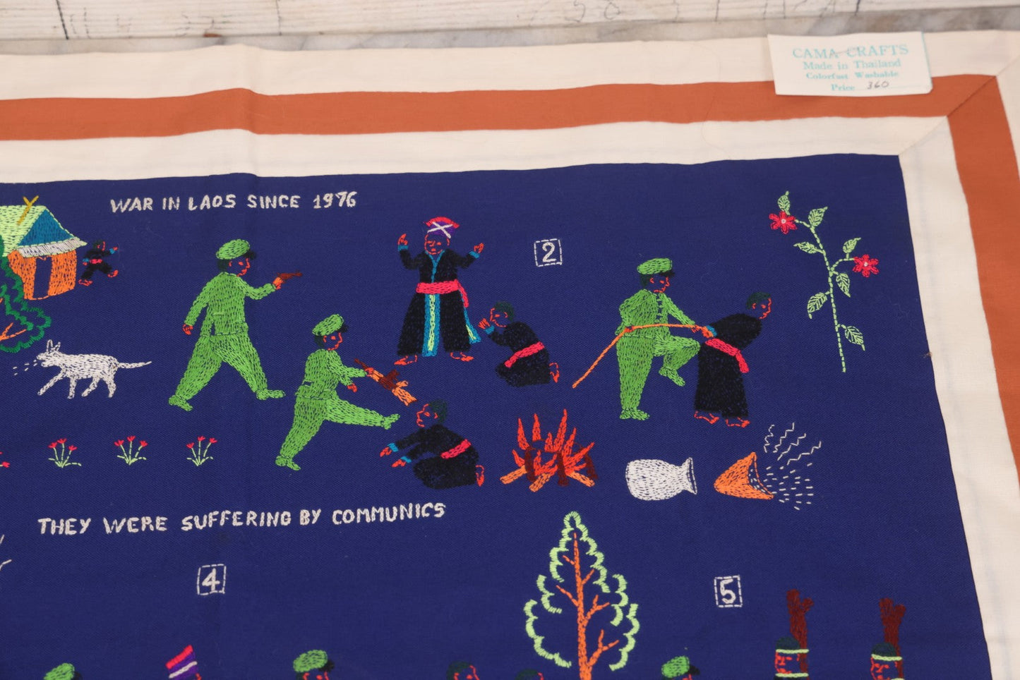 Lot 017 - Pair Of Vintage Folk Art Embroidered Hmong Story Cloths (Paj Ntaub) Illustrating "The War In Laos Since 1976" Across 13 Scenes, Artist Signed Mee Xiong, With Gallery Label From Cama Crafts, Made In Thailand, Circa 1990s