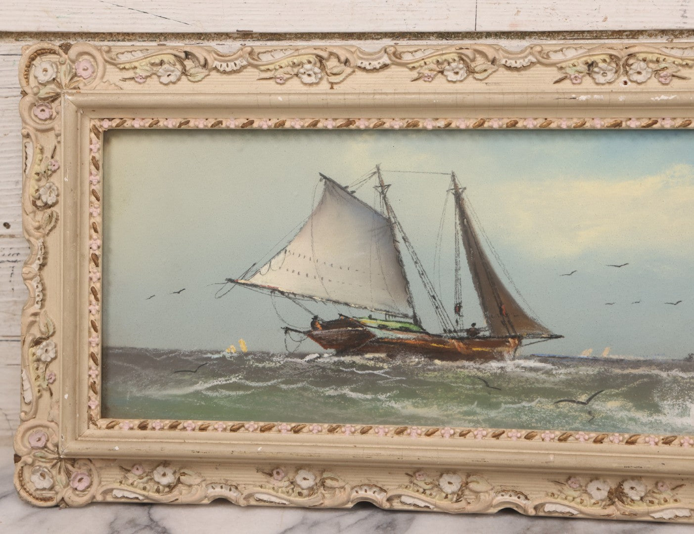Lot 024 - Antique Nautical Pastel Painting Of A Sailing Ship On Choppy Waters, With Coastal Mountains, Other Ships In Background, Artist Signed M. Dulmy, In Original Painted Pressed Gesso Custom Frame, 23" x 9"