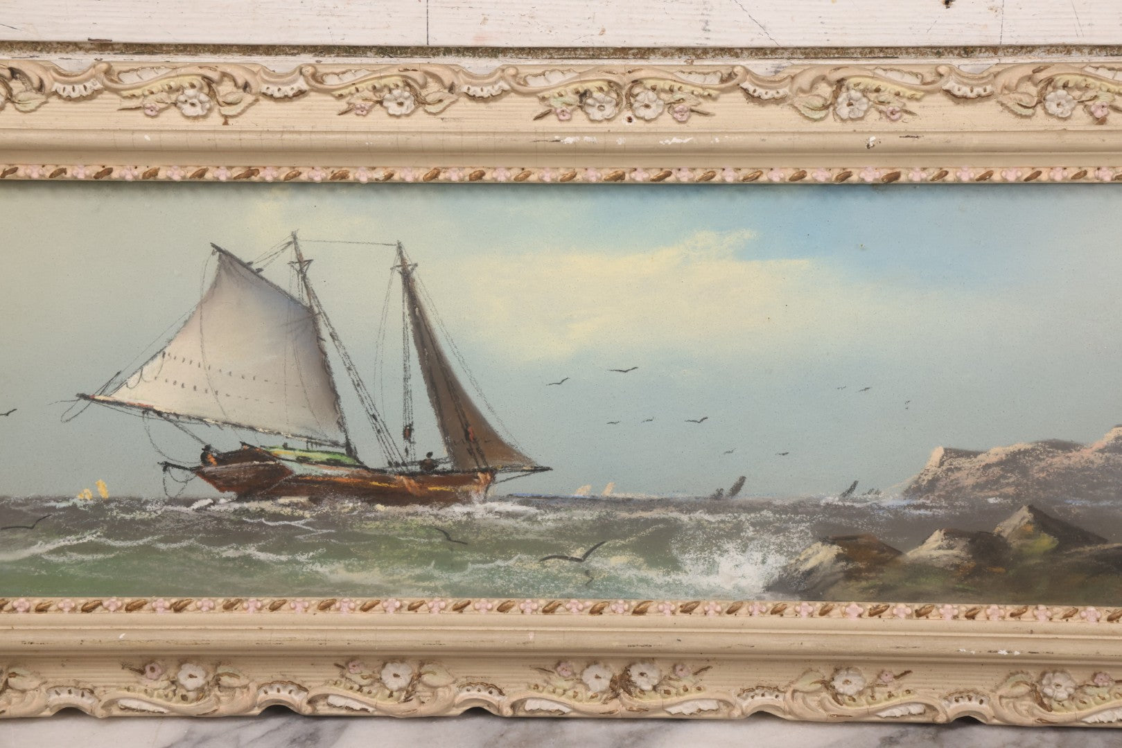 Lot 024 - Antique Nautical Pastel Painting Of A Sailing Ship On Choppy Waters, With Coastal Mountains, Other Ships In Background, Artist Signed M. Dulmy, In Original Painted Pressed Gesso Custom Frame, 23" x 9"