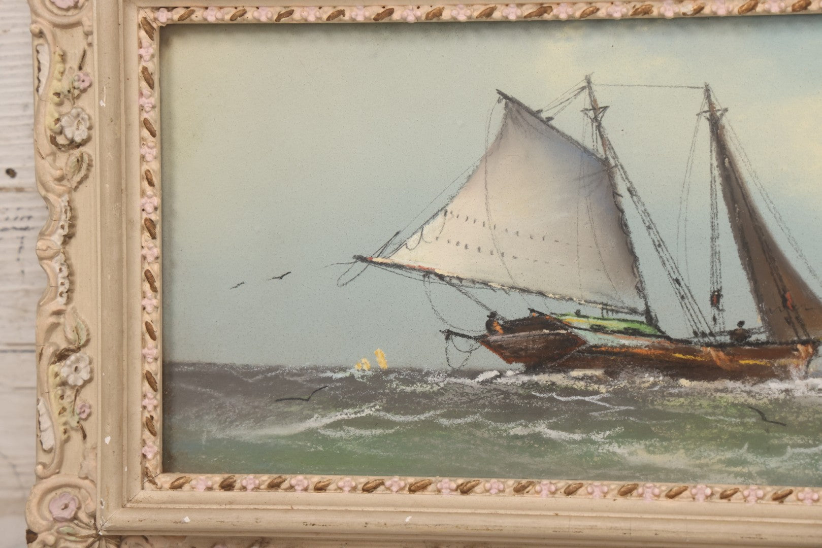 Lot 024 - Antique Nautical Pastel Painting Of A Sailing Ship On Choppy Waters, With Coastal Mountains, Other Ships In Background, Artist Signed M. Dulmy, In Original Painted Pressed Gesso Custom Frame, 23" x 9"