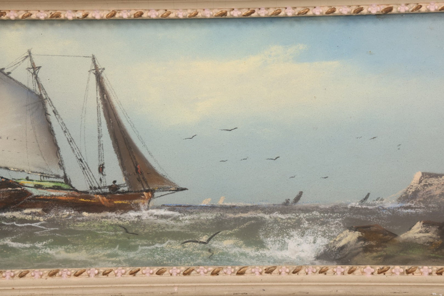 Lot 024 - Antique Nautical Pastel Painting Of A Sailing Ship On Choppy Waters, With Coastal Mountains, Other Ships In Background, Artist Signed M. Dulmy, In Original Painted Pressed Gesso Custom Frame, 23" x 9"