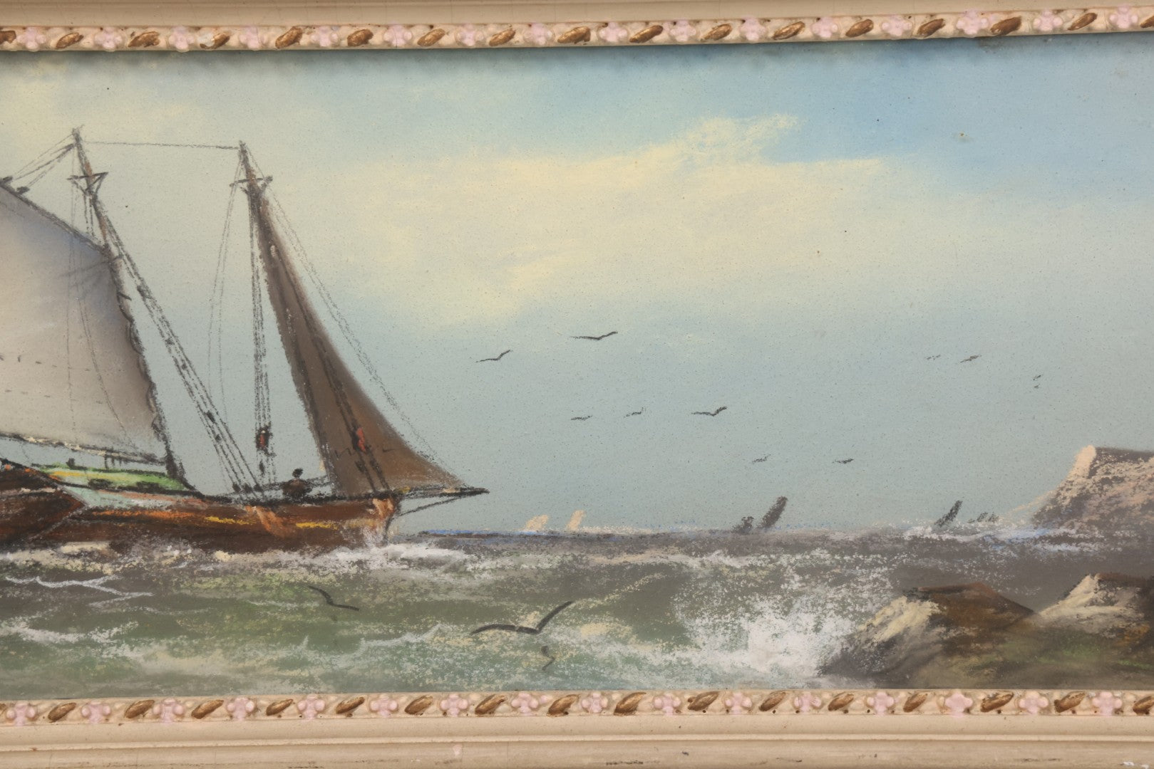 Lot 024 - Antique Nautical Pastel Painting Of A Sailing Ship On Choppy Waters, With Coastal Mountains, Other Ships In Background, Artist Signed M. Dulmy, In Original Painted Pressed Gesso Custom Frame, 23" x 9"