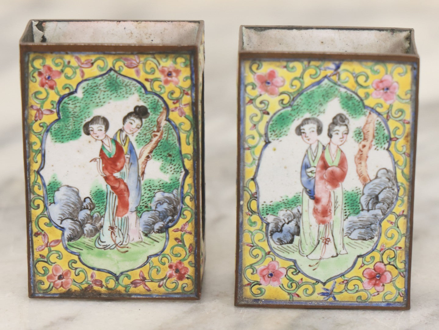 Lot 033 - Pair Of Vintage Hand Painted Metal And Porcelain Matchbox Holders, Featuring Pair Of Japanese Women In Kimonos In Various Standing Poses, Yellow Surround With Pink And Blue Flowers