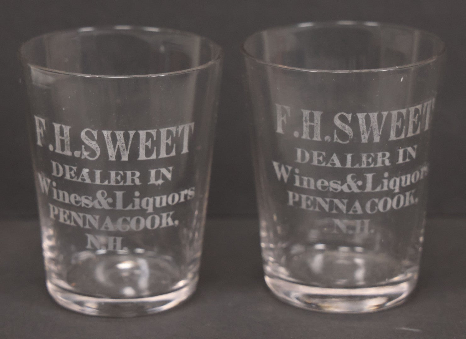 Lot 056 - Pair Of Vintage Glass Shot Glasses Advertising F.H. Sweet, Dealer In Wines & Liquors, Pennacook, New Hampshire