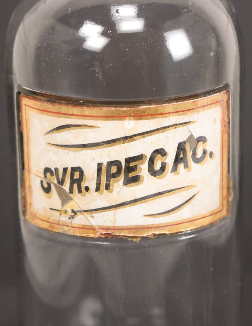 Lot 057 - Grouping Of Three Antique Glass Apothecary Bottles With Reverse Painted Glass Labels Including Syrup Of Ipecac (Syr. Ipecac.), Blackberry Wine (Vin. Rubi Vill.), And Port Wine (Vin. Oporto)