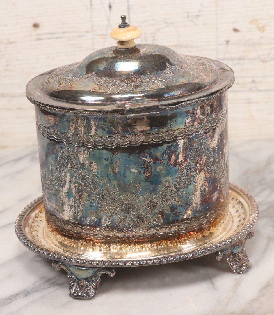 Lot 070 - Antique Etched Silverplate Single Piece Lidded Jar With Hinged Lid And Bone Handle On Slotted Tray With Feet, With Flower And Leaf Wreaths And Rope Twist Motifs, Marked J. E. & S. Ltd., Made In England, 7-1/2" Height