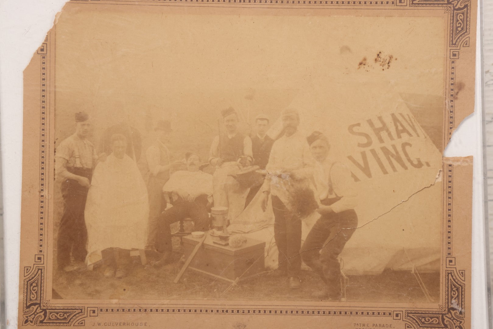 Lot 083 - Antique Boarded Photograph Of Soldier's Shaving Tent With Men Posing With Rifles, Barber, Implements And Tools, Photo By J.W. Culverhouse, " 7A The Parade, Trowbridge" Wiltshire, England, Note Photo Damaged, Losses