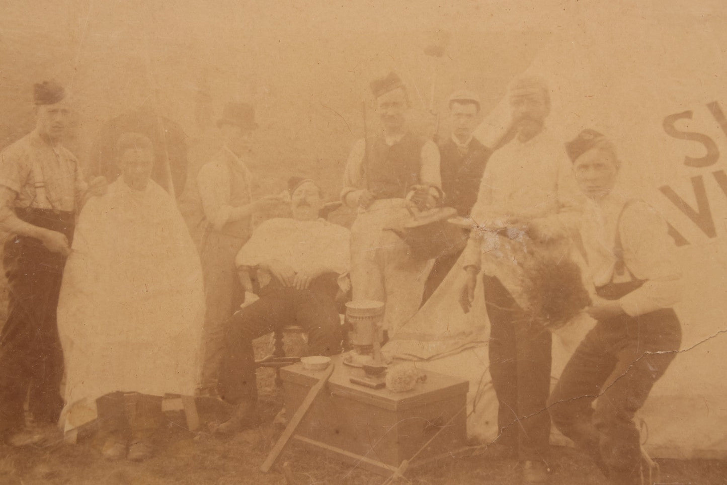 Lot 083 - Antique Boarded Photograph Of Soldier's Shaving Tent With Men Posing With Rifles, Barber, Implements And Tools, Photo By J.W. Culverhouse, " 7A The Parade, Trowbridge" Wiltshire, England, Note Photo Damaged, Losses