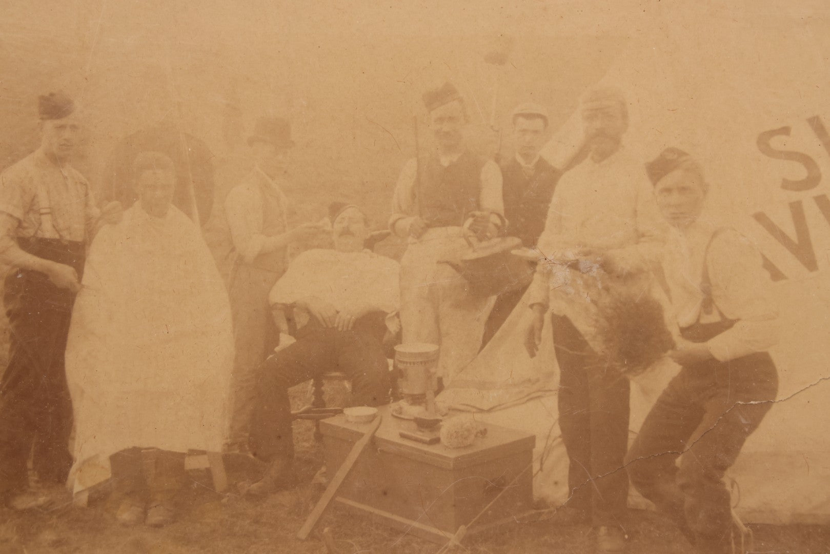 Lot 083 - Antique Boarded Photograph Of Soldier's Shaving Tent With Men Posing With Rifles, Barber, Implements And Tools, Photo By J.W. Culverhouse, " 7A The Parade, Trowbridge" Wiltshire, England, Note Photo Damaged, Losses
