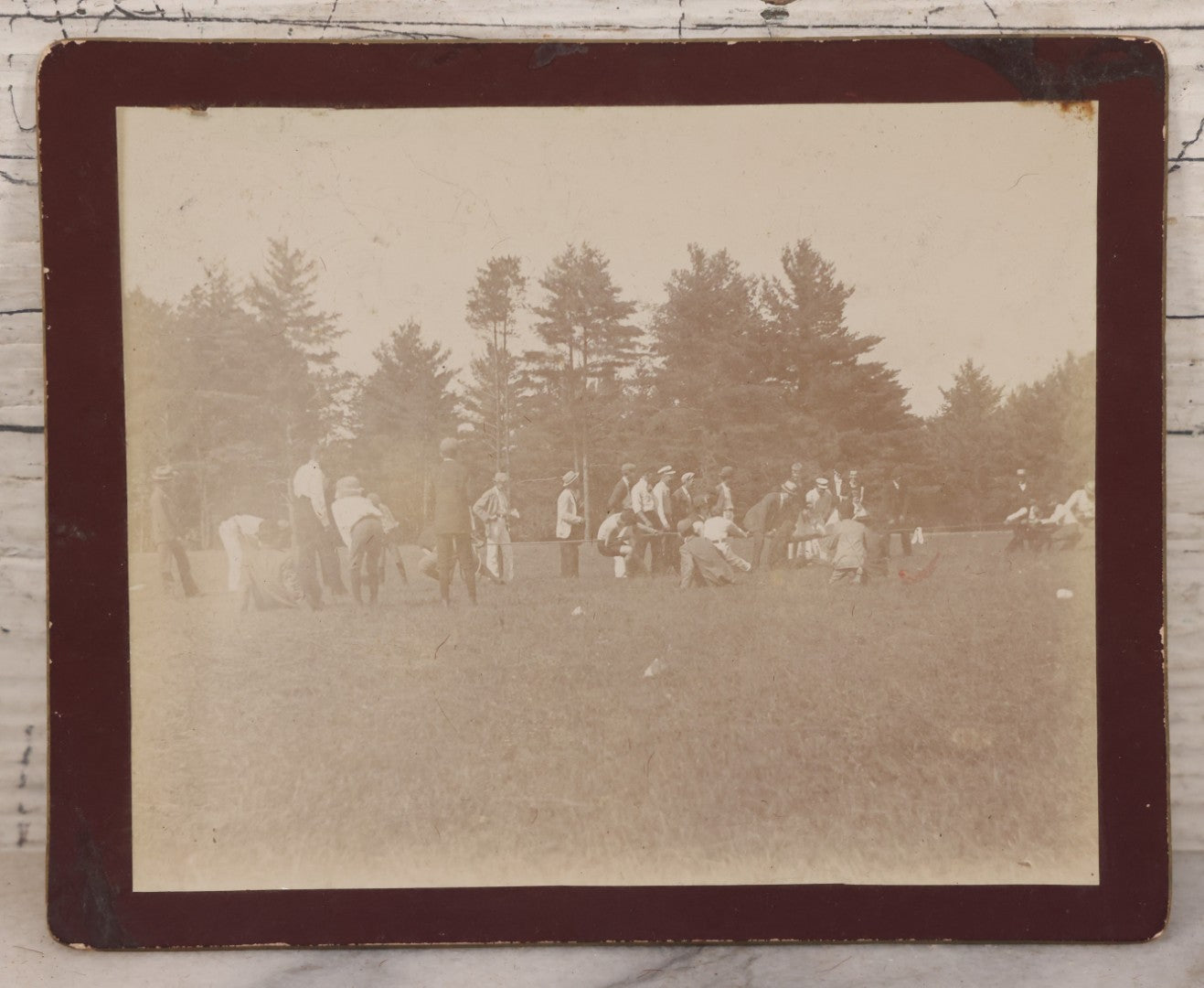 Lot 084 - Antique Boarded Photograph Of A Group Of Adults Engaged In A Tug-O-War Game In A Field