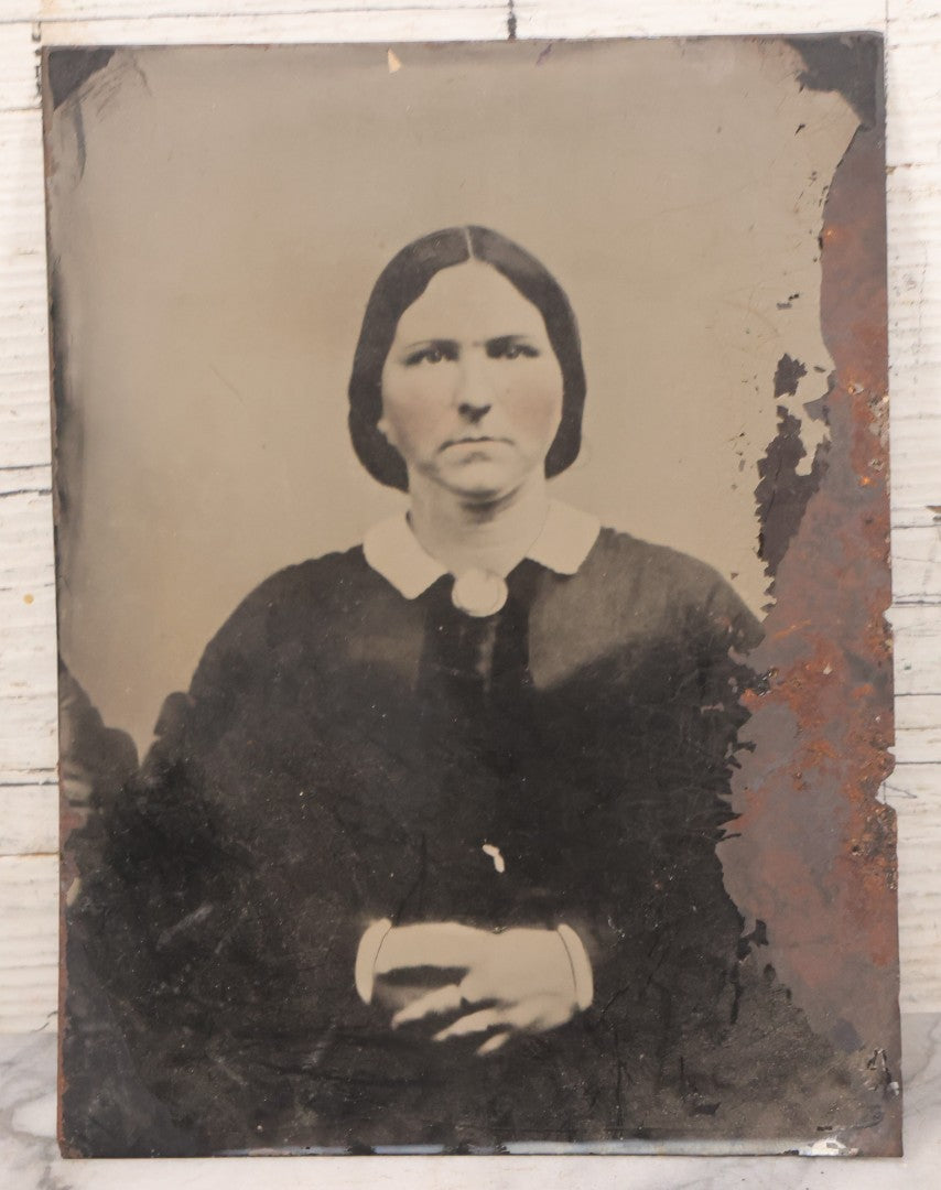 Lot 085 - Pair Of Antique Tintype Photographs Including Half Plate Tintype Of A Young Girl With Striped Socks And A Full Plate Tintype Of A Serious Looking Woman With Folded Hands