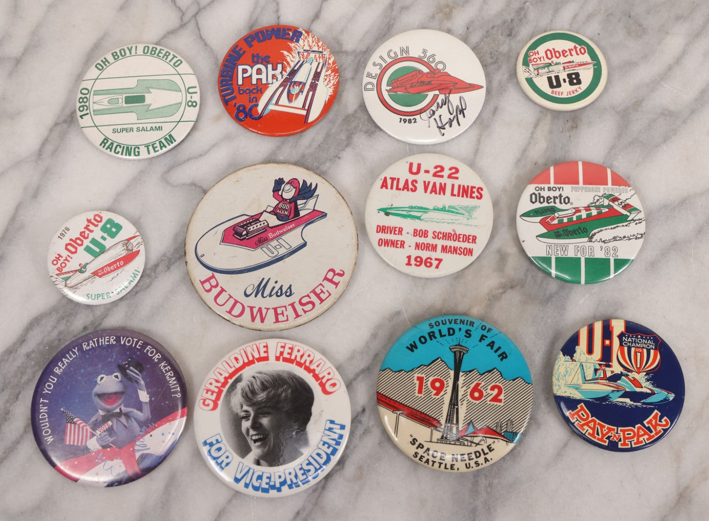 Lot 094 - Vintage Grouping Of 12 Buttons, Including Signed Jerry Hopp Button, "Super Salami" Racing Buttons, Vote For Kermit Button, Others