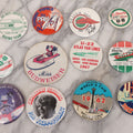 Lot 094 - Vintage Grouping Of 12 Buttons, Including Signed Jerry Hopp Button, "Super Salami" Racing Buttons, Vote For Kermit Button, Others