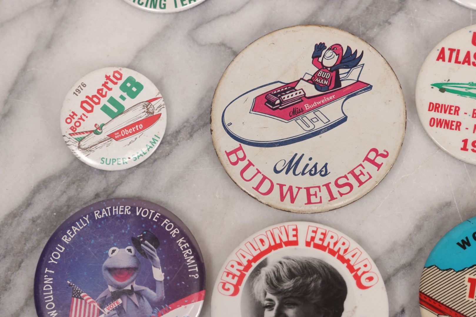Lot 094 - Vintage Grouping Of 12 Buttons, Including Signed Jerry Hopp Button, "Super Salami" Racing Buttons, Vote For Kermit Button, Others