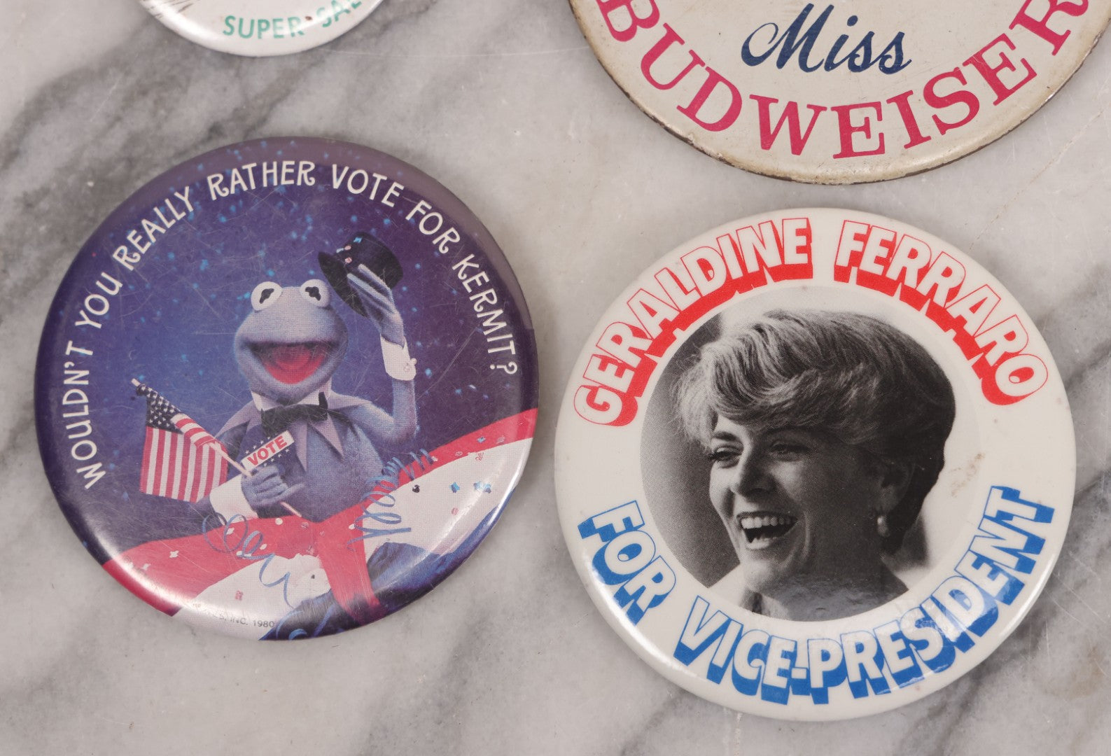 Lot 094 - Vintage Grouping Of 12 Buttons, Including Signed Jerry Hopp Button, "Super Salami" Racing Buttons, Vote For Kermit Button, Others