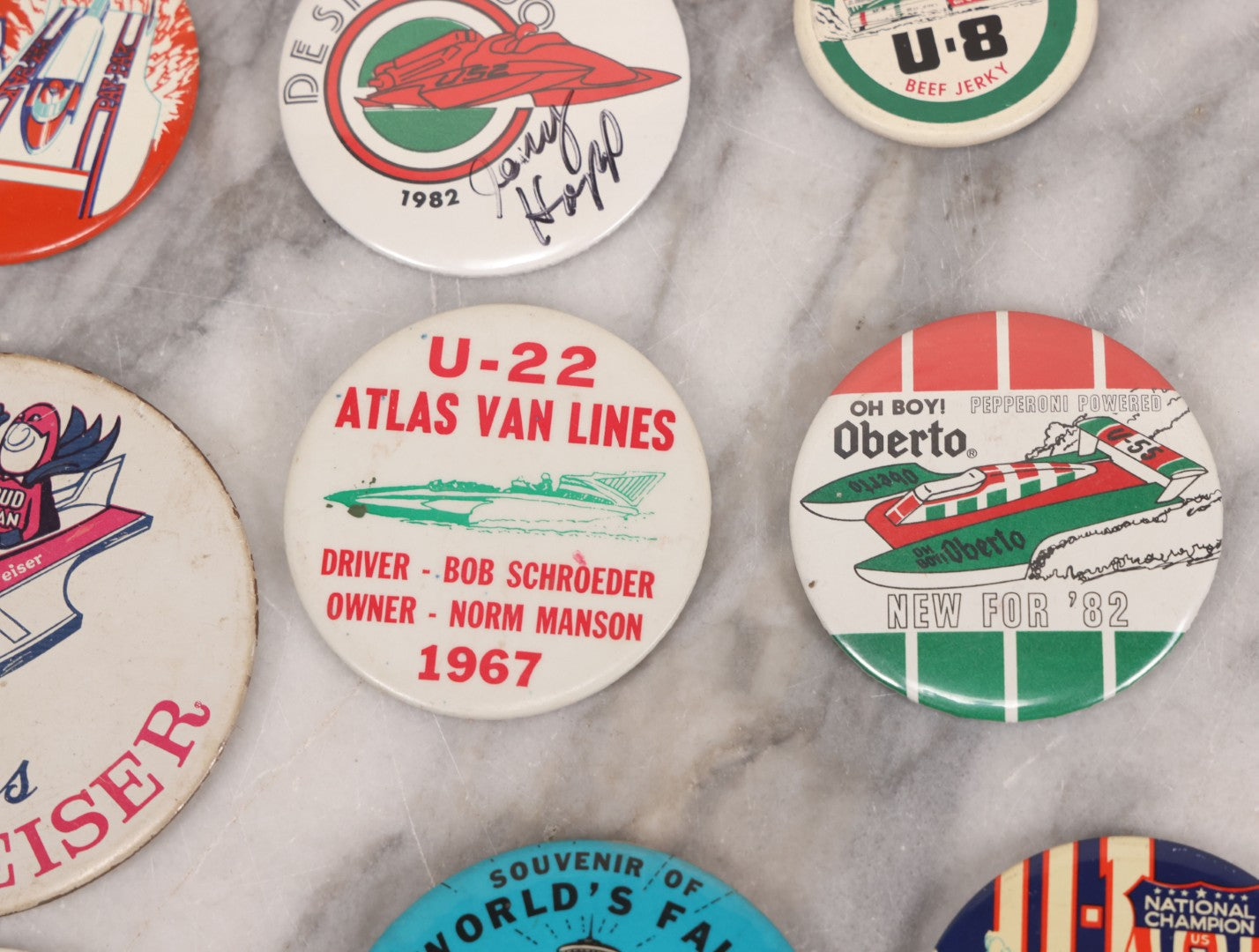 Lot 094 - Vintage Grouping Of 12 Buttons, Including Signed Jerry Hopp Button, "Super Salami" Racing Buttons, Vote For Kermit Button, Others