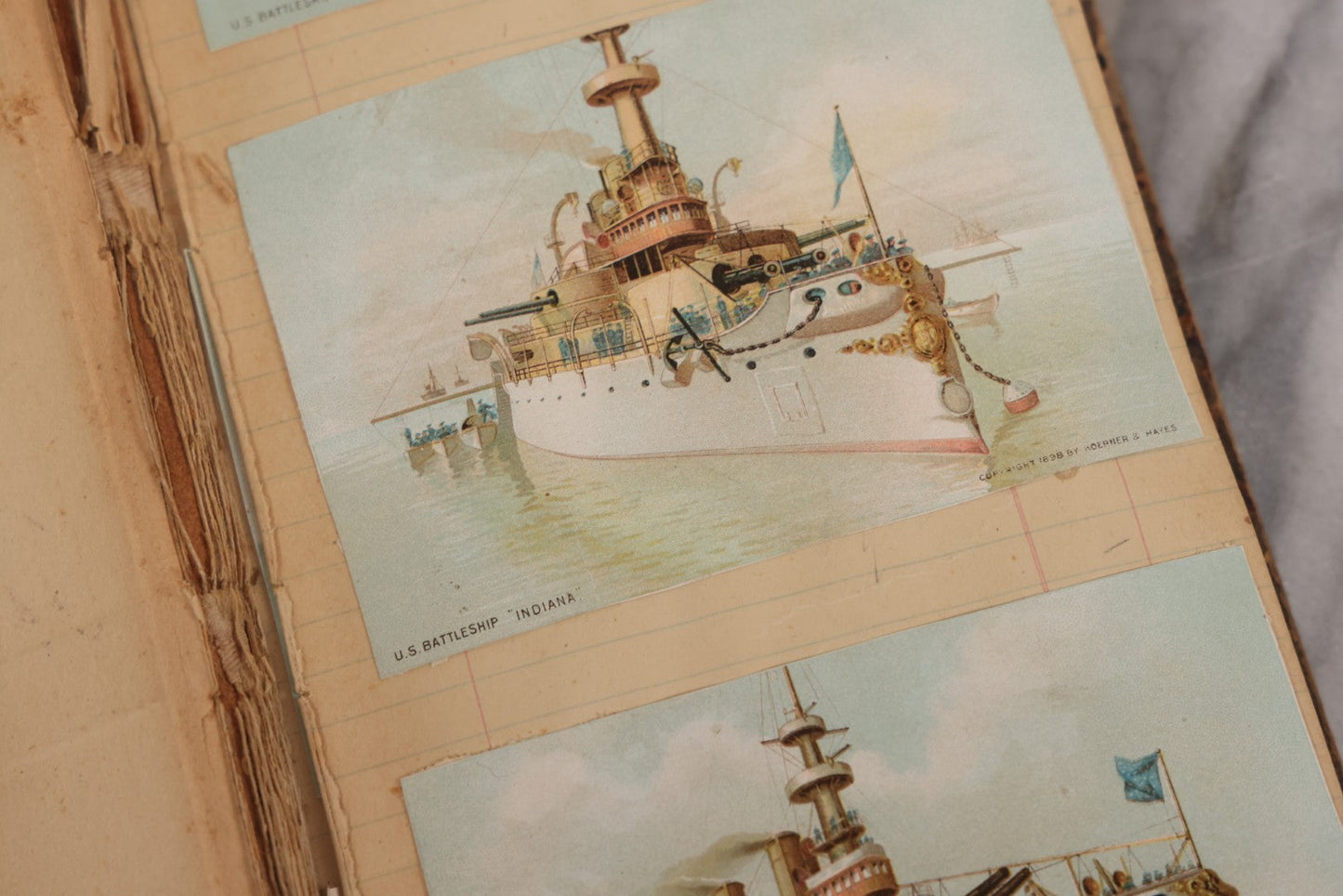 Lot 118 - Antique Scrapbook Album Made From An Old Cash Book Ledger Containing 15 Lithographed Card Featuring United States Battleships Of The Spanish American War Era, Cards Copyright 1898 By Koerner & Hayes, With Four Additional Cards, Doodles, Etc.