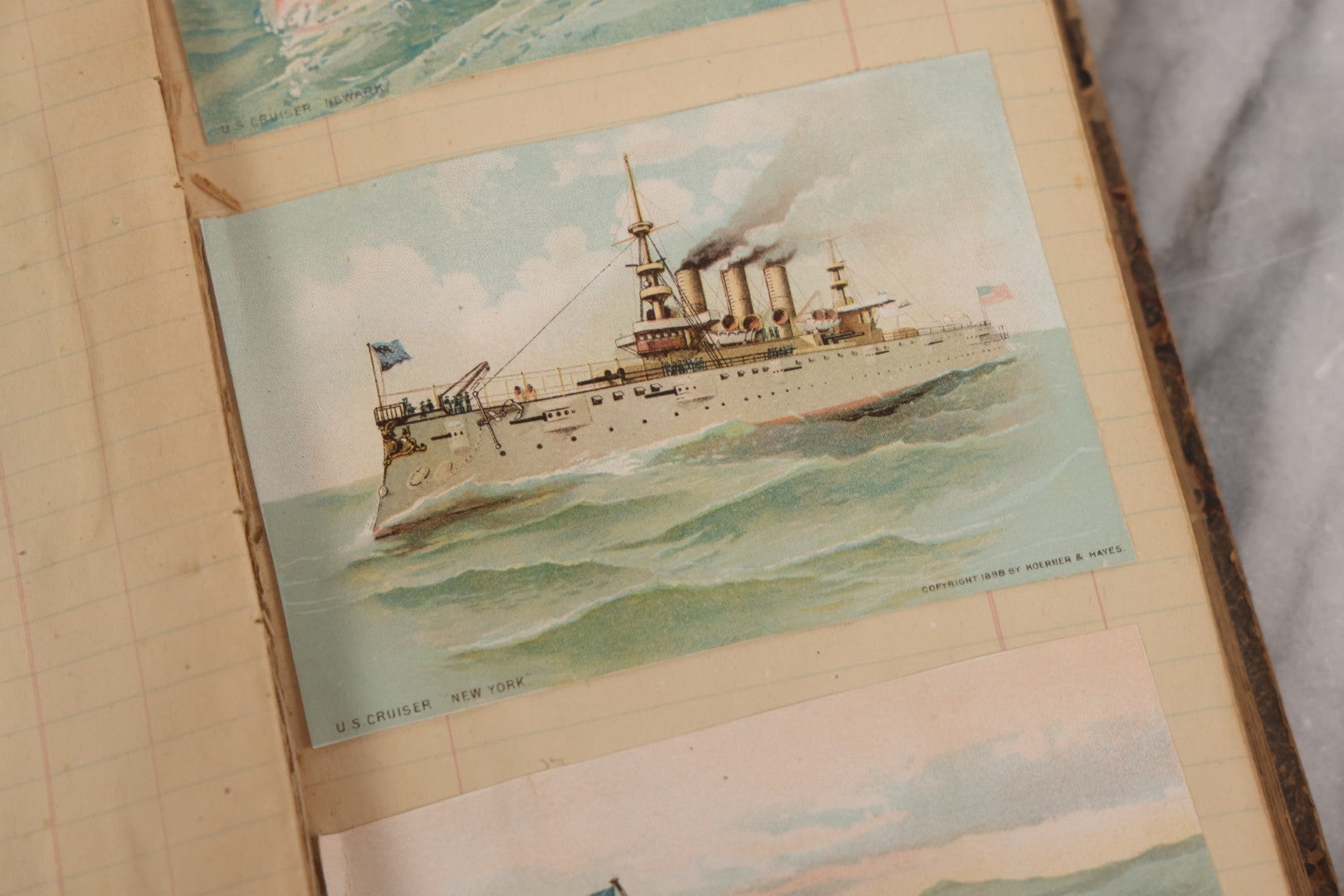 Lot 118 - Antique Scrapbook Album Made From An Old Cash Book Ledger Containing 15 Lithographed Card Featuring United States Battleships Of The Spanish American War Era, Cards Copyright 1898 By Koerner & Hayes, With Four Additional Cards, Doodles, Etc.