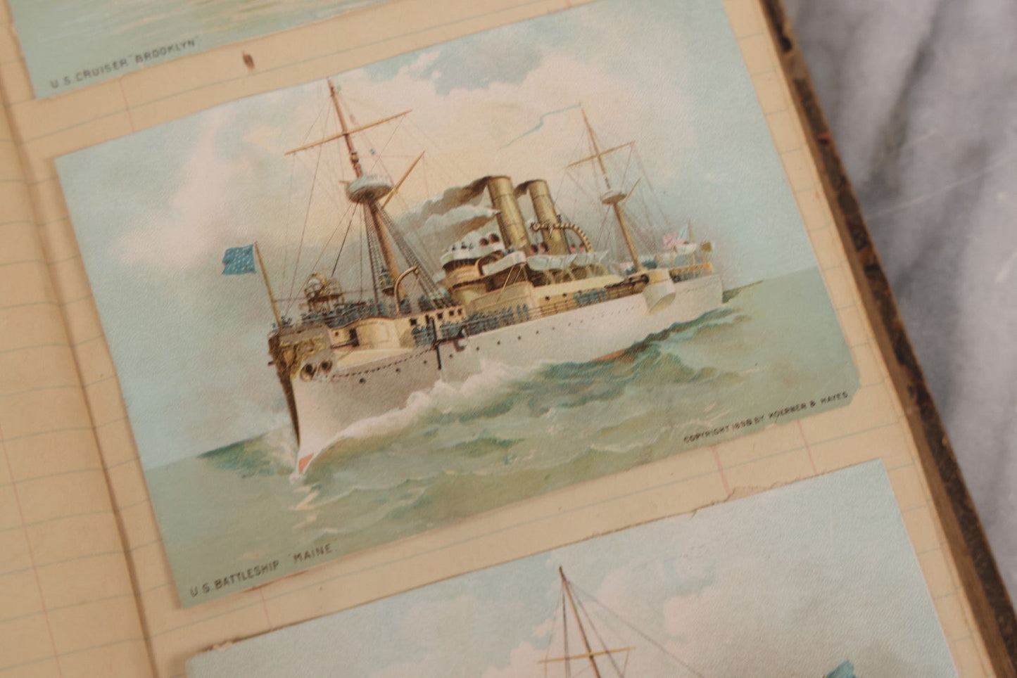 Lot 118 - Antique Scrapbook Album Made From An Old Cash Book Ledger Containing 15 Lithographed Card Featuring United States Battleships Of The Spanish American War Era, Cards Copyright 1898 By Koerner & Hayes, With Four Additional Cards, Doodles, Etc.