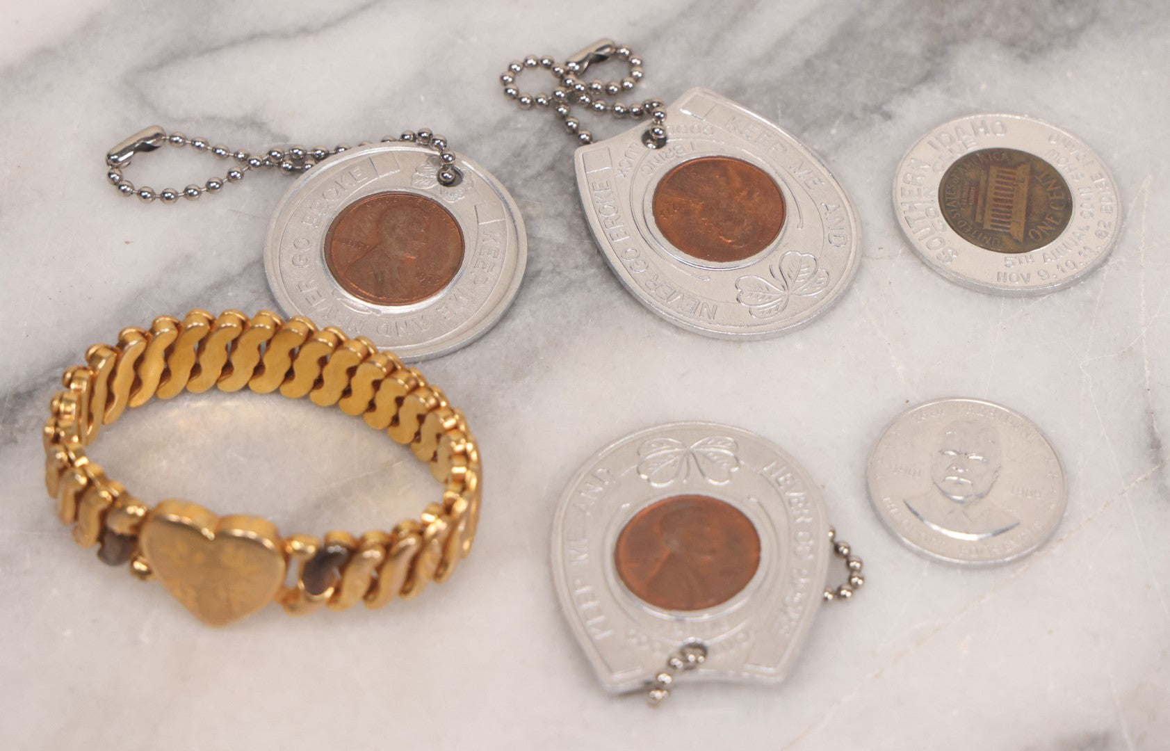 Lot 152 - Vintage Grouping Of Four  Souvenir Coin Dogtags, "Keep Me And Never Go Broke" Penny Souvenir, Shell's Coin Game Souvenir Coin, And Heart Locket Expanding Bracelet