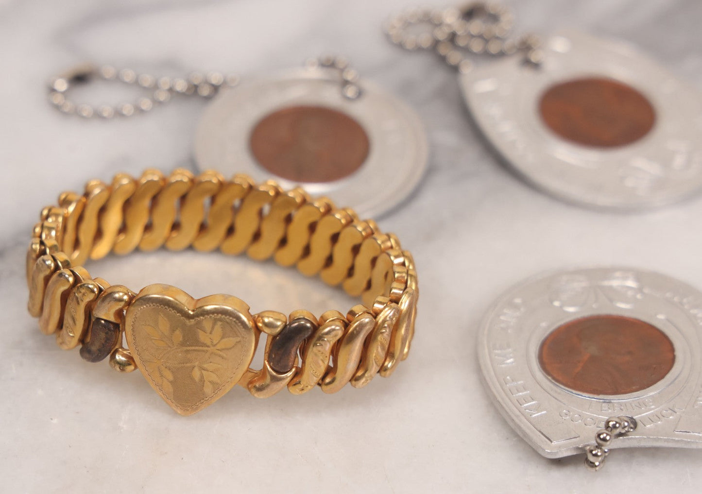 Lot 152 - Vintage Grouping Of Four  Souvenir Coin Dogtags, "Keep Me And Never Go Broke" Penny Souvenir, Shell's Coin Game Souvenir Coin, And Heart Locket Expanding Bracelet