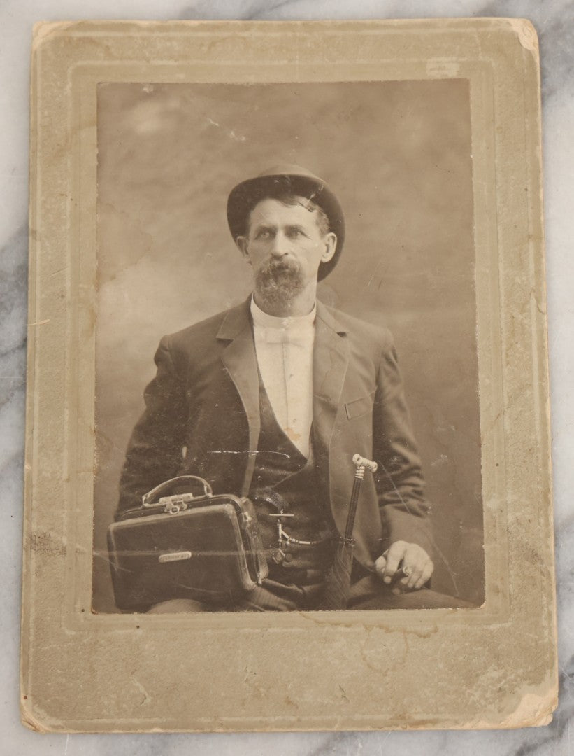 Lot 027 - Pair Of Antique Boarded Photographs Of Dr. Julius Benson Evans In Life And Death, Including Occupational Photo Of Doctor With Bag, And Post Mortem Photo Of Deceased Doctor Lying At Rest