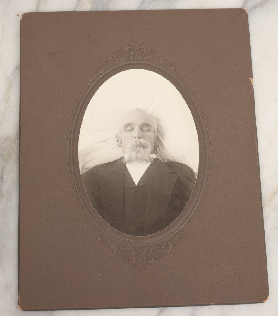 Lot 027 - Pair Of Antique Boarded Photographs Of Dr. Julius Benson Evans In Life And Death, Including Occupational Photo Of Doctor With Bag, And Post Mortem Photo Of Deceased Doctor Lying At Rest