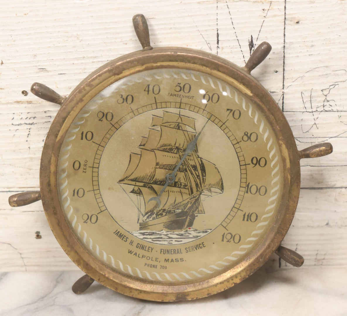Lot 045 - Vintage Brass Advertising Thermometer With Nautical Motifs, Ship Wheel, Advertising James H. Ginley, Funeral Service, Walpole, Massachusetts