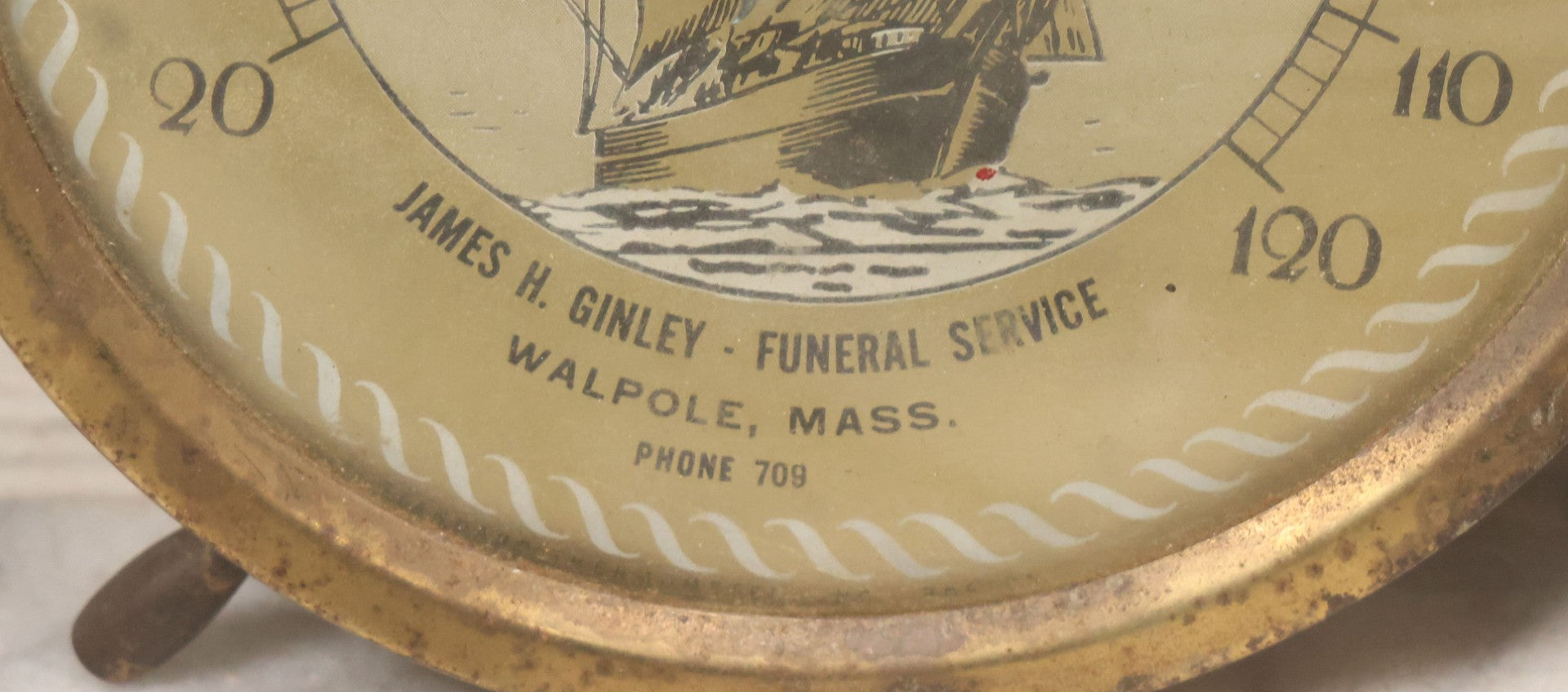 Lot 045 - Vintage Brass Advertising Thermometer With Nautical Motifs, Ship Wheel, Advertising James H. Ginley, Funeral Service, Walpole, Massachusetts