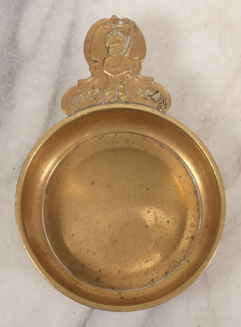 Lot 053 - Antique Brass Tastevin Wine Up With Soldier Figure, Commemorating 25th Anniversary Of Something, 1899-1924