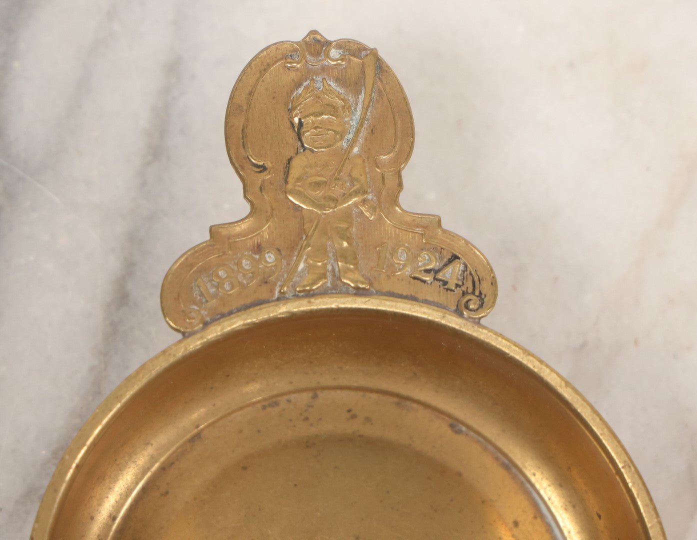 Lot 053 - Antique Brass Tastevin Wine Up With Soldier Figure, Commemorating 25th Anniversary Of Something, 1899-1924