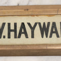 Lot 062 - Vintage Reverse Painted Name Plate Door Tag For G.W. Hayward In Brass Mounting Frame, Note Cracked, 7-5/8" x 3"