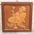Lot 077 - Vintage Hand Carved German Folk Art Wall Hanger, Drunkard Drinking At Table, 9-1/2" x 9-1/2"