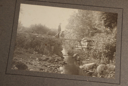 Lot 131 - Pair Of Antique Boarded Photographs Of Outdoor Scenes, Including Boy And Girl On Primitive Stick Bridge Crossing Creek, Canoe