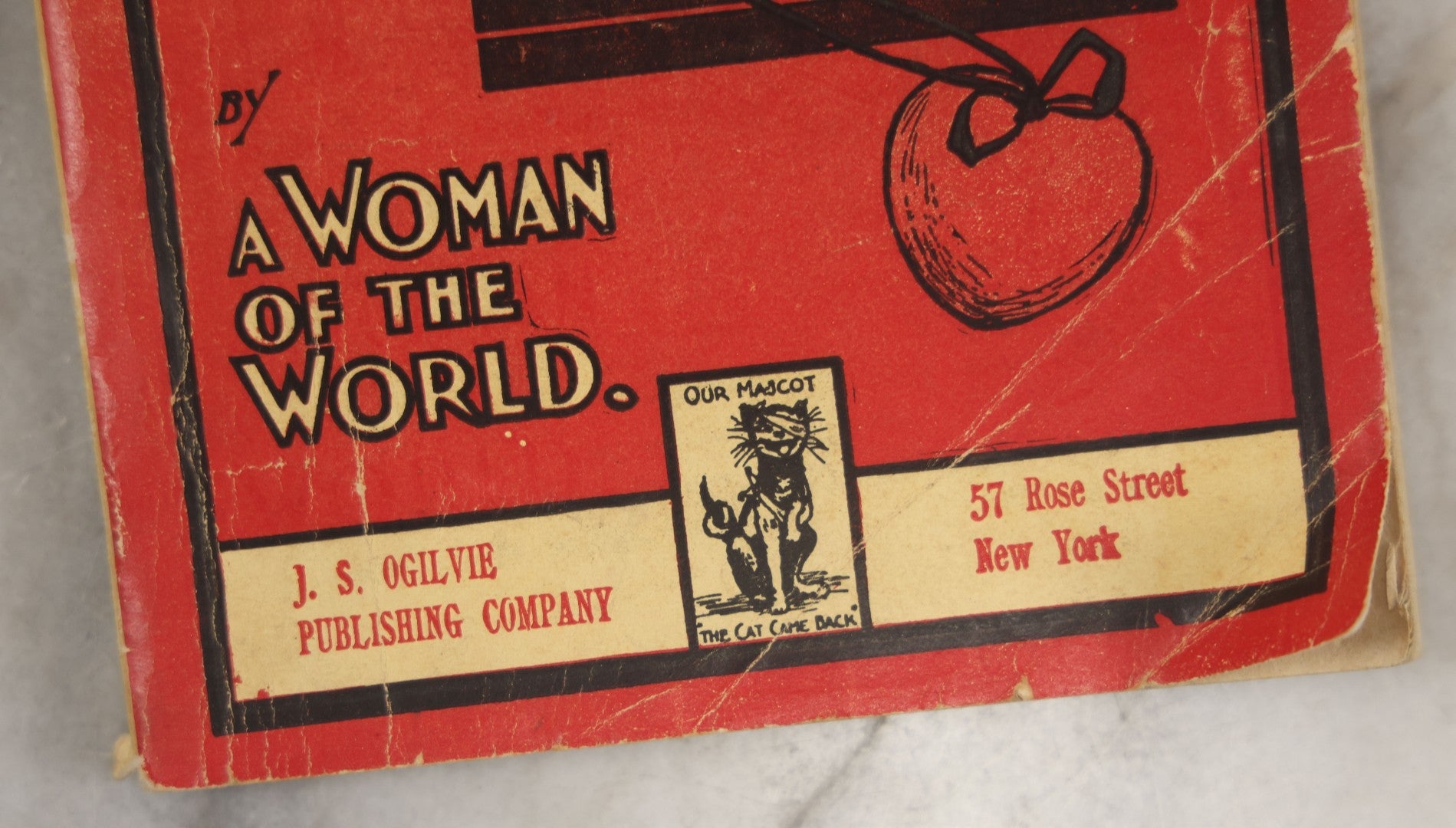 Lot 266 - "Love, Courtship, Marriage By A Woman Of The World" Antique Illustrated Paperback With Cupid Illustration On Cover And Bandaged Cat Mascot, J.S. Ogilvie, Publisher, New York, 1902, "A Hundred Ways Of Kissing Girls" Advertisement On Back Cover