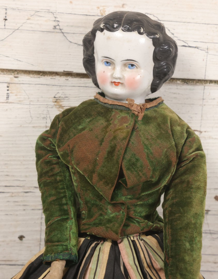 Lot 011 - Antique Victorian China Head Doll With Custom Outfit Including Velvet Blazer, Green, Pink, Yellow, And Black Striped Skirt, Knit Underskirt, White And Pink Pantyhose, And Black Stockings, 20" H