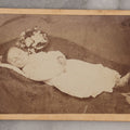 Lot 025 - Antique Post Mortem Carte De Visite C.D.V. Photograph Of A Deceased Toddler Lying At Rest, With Flower Beside Head, Photographed at G.A. Johnson's Art Gallery, St. Petersburg, Florida