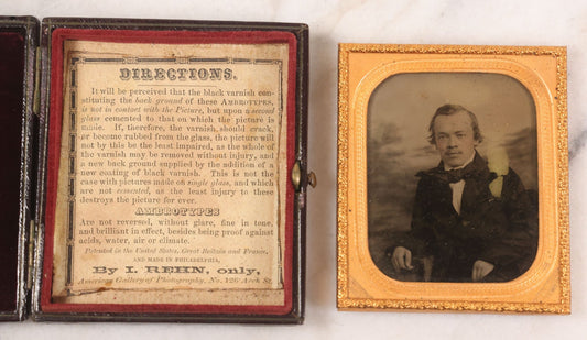 Lot 033 - Antique 1/6th Plate Ambrotype Photograph Of A Young Man With Mustache, Slight Smile, Photographed By I. Rehn, Philadelphia, With Note From Rehn In Case Regarding Care Of Ambrotypes, In Intact Leatherette Union Case, Note Loss To Black Varnish